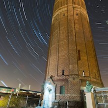 time-lapse photo of Lund Observatory at night with stars circling overhead