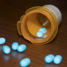 photo of blue pills spilled out of a prescription bottle