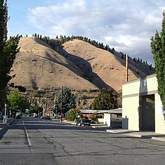 a street in rural Cashmere WA with semi-arid hills rising behind town